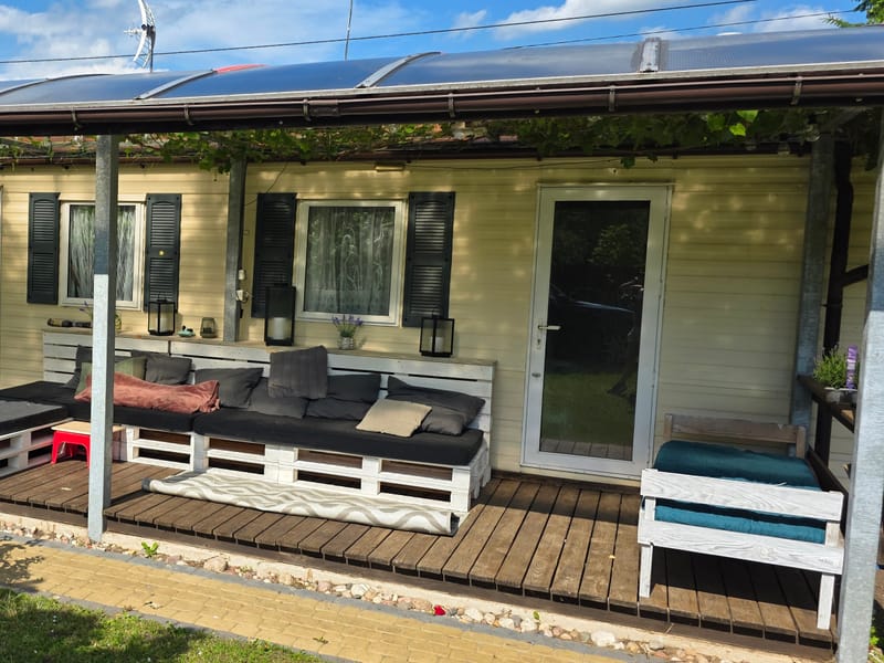 Überdachte Terrasse mit Sitzmöbeln am Ferienhaus